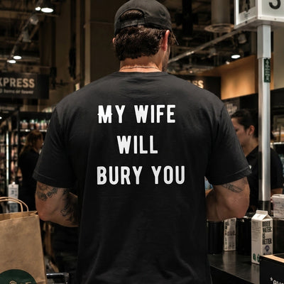 Person wearing a black t-shirt with text in a grocery store
